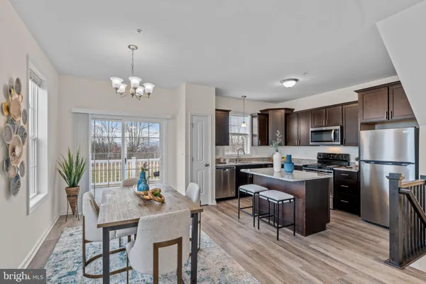 a kitchen with refrigerator cabinets dining table and chairs