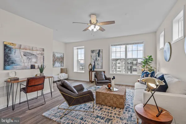 a living room with furniture a chandelier and a large window
