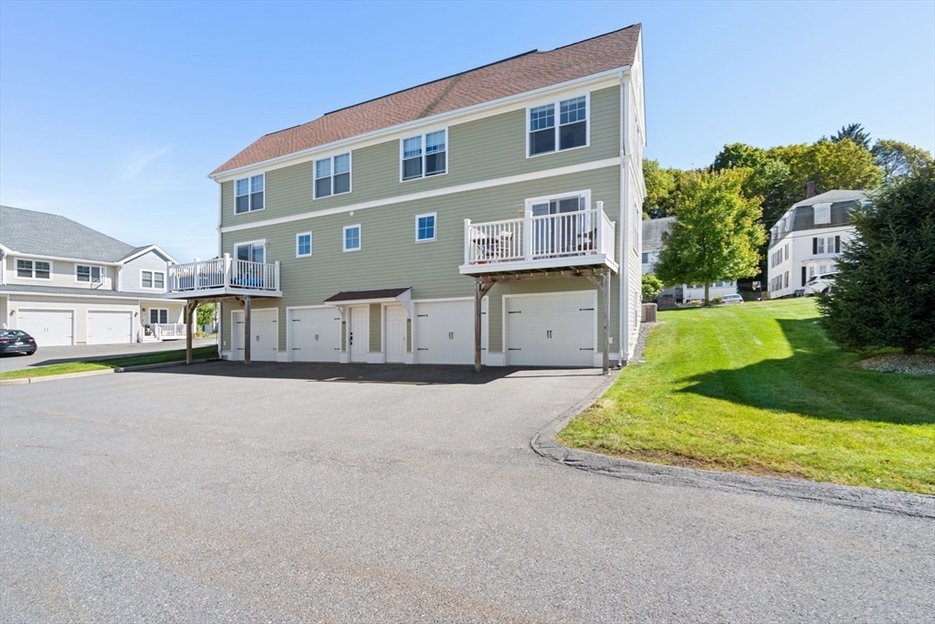 78 Oak Street, Unit 78 Clinton, MA 01510 - Photo 21 of 22 a front view of a house with a yard and garage
