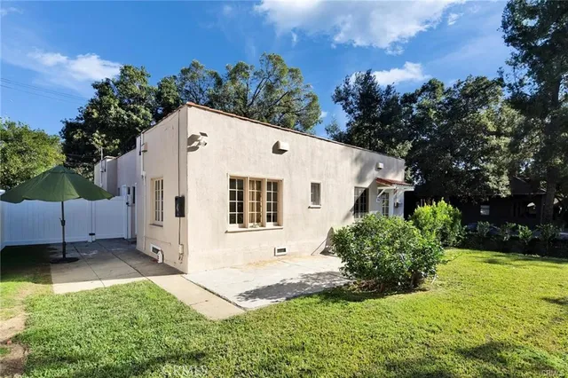 a view of a white house with yard and a garden