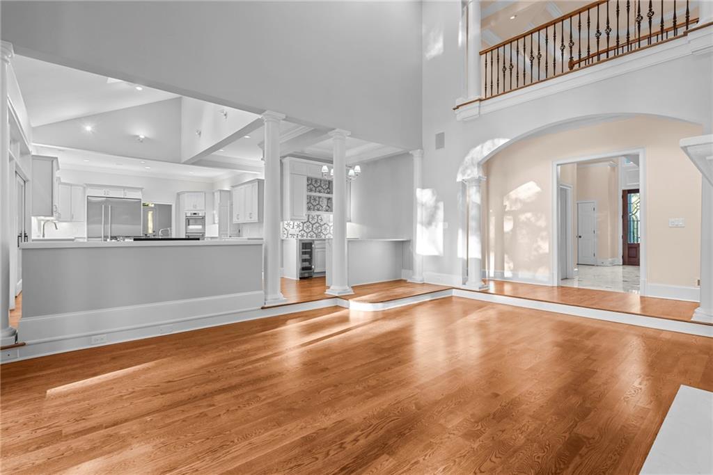 520 Chestnut Rose Lane Sandy Springs, GA 30327 - Photo 11 of 94 a view of an empty room with wooden floor and a kitchen