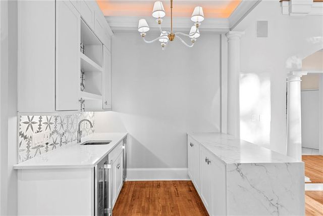 a kitchen with granite countertop white cabinets and stainless steel appliances