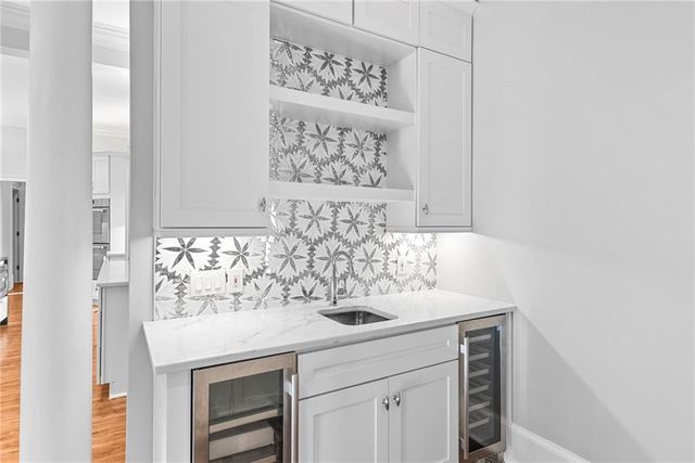 a kitchen with granite countertop white cabinets and stainless steel appliances