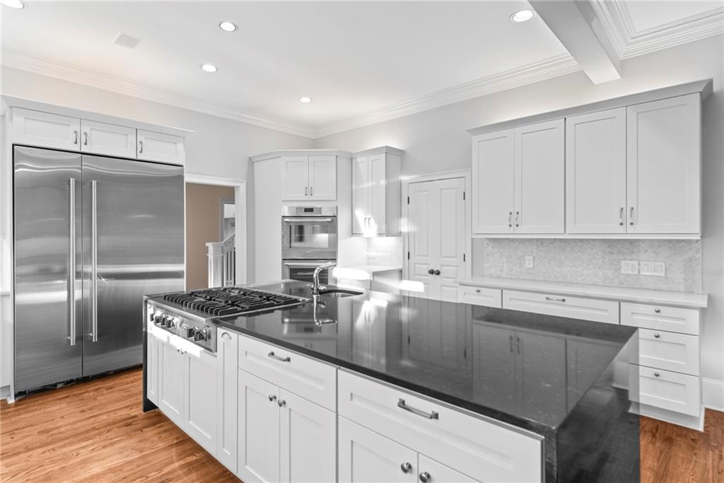 520 Chestnut Rose Lane Sandy Springs, GA 30327 - Photo 26 of 94 a kitchen with granite countertop white cabinets and stainless steel appliances