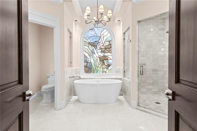 a bathroom with a granite countertop sink toilet and mirror