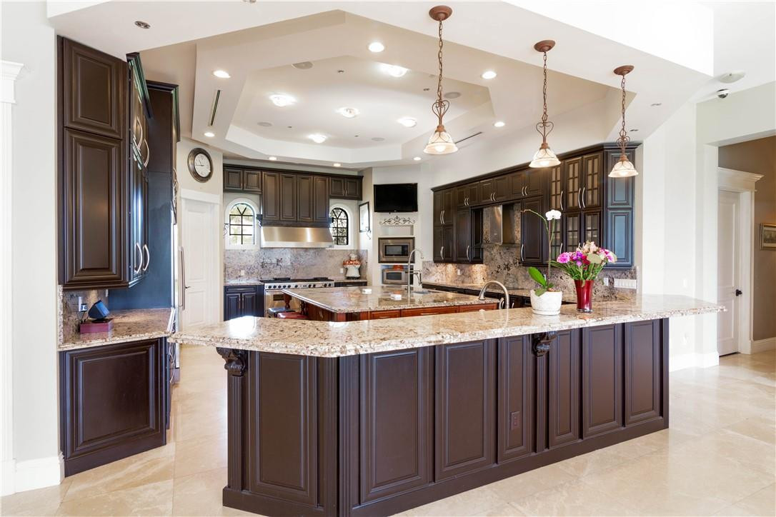 5600 Southwest 136th Avenue Southwest Ranches, FL 33330 - Photo 16 of 32 a kitchen with kitchen island granite countertop a sink stainless steel appliances and cabinets