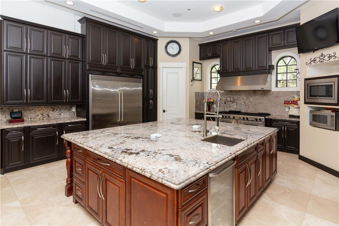 5600 Southwest 136th Avenue Southwest Ranches, FL 33330 - Photo 17 of 32 a kitchen with granite countertop a sink stove and refrigerator