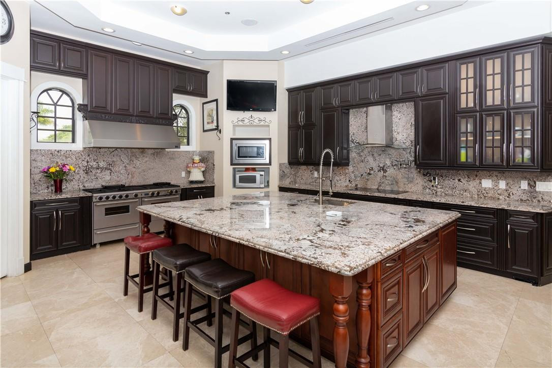 5600 Southwest 136th Avenue Southwest Ranches, FL 33330 - Photo 18 of 32 a kitchen with stainless steel appliances granite countertop a stove a sink and a refrigerator
