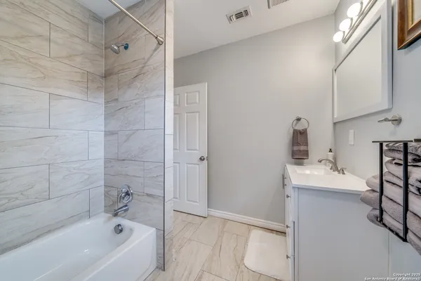 a bathroom with a tub a sink and a shower