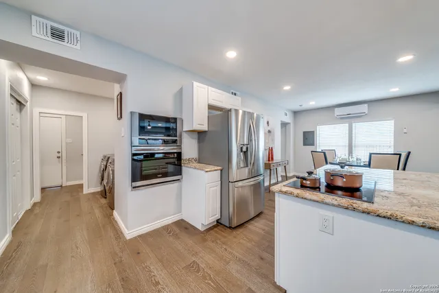 a kitchen with stainless steel appliances granite countertop a refrigerator a stove a sink and a microwave