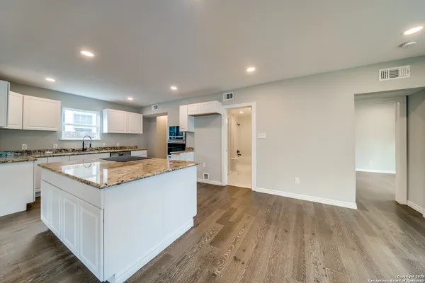 a kitchen with stainless steel appliances granite countertop sink stove refrigerator and cabinets