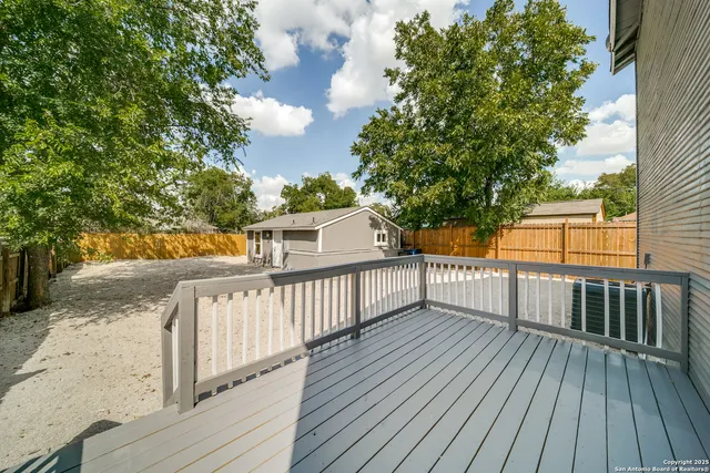 a view of a house with a yard and large tree