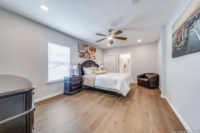 a bedroom with a bed a chandelier and a window