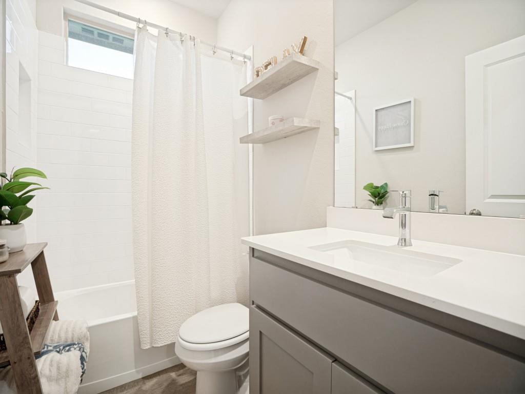 1612 Reed Drive Krum, TX 76249 - Photo 21 of 25 Bathroom featuring a white subway tile tub surround, transom window, grey vanity with an integrated sink, polished chrome faucet, and wood-finish flooring