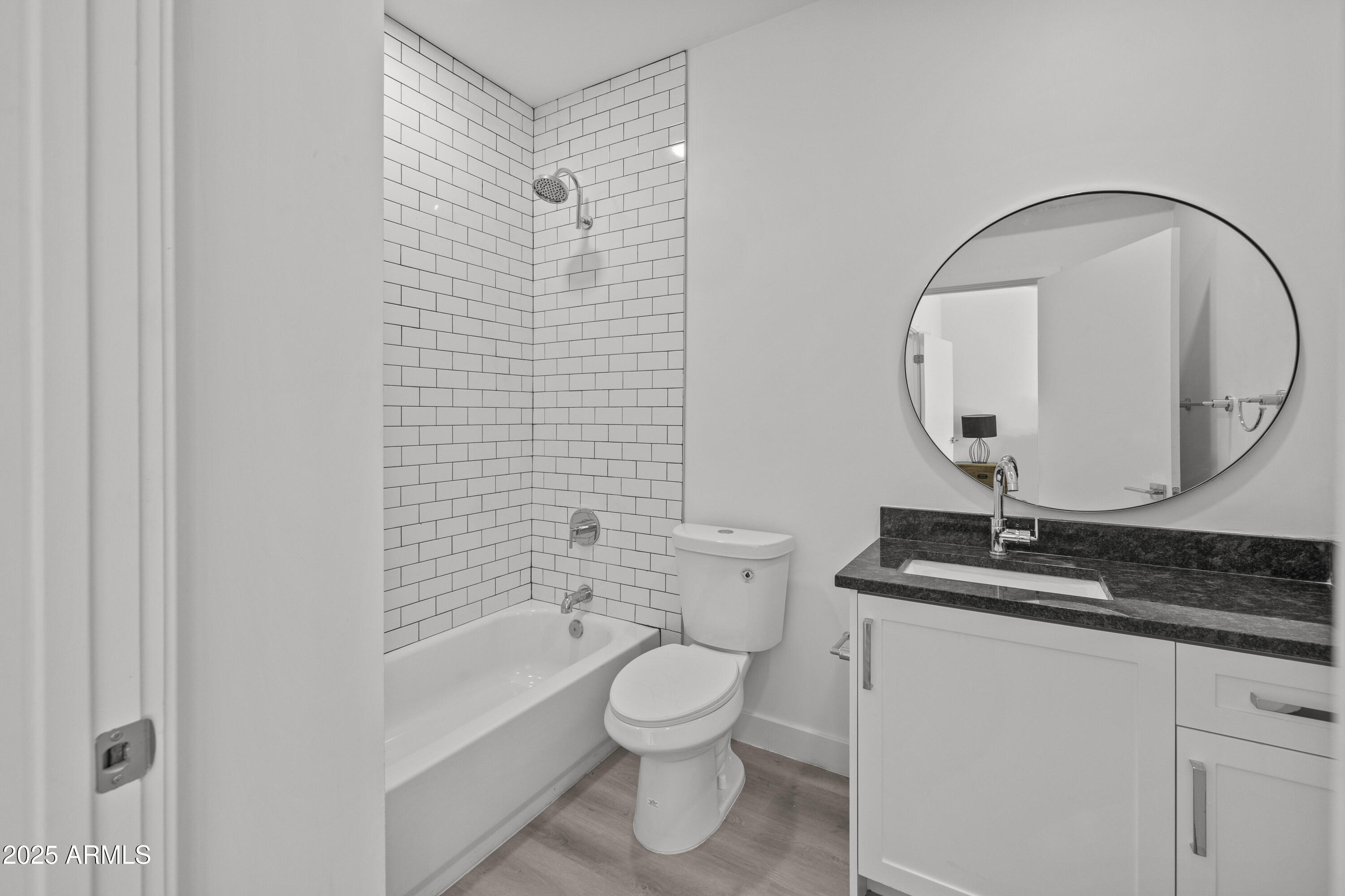 3130 North 37th Street, Unit 13 Phoenix, AZ 85018 - Photo 9 of 15 a bathroom with a granite countertop toilet a sink and a mirror