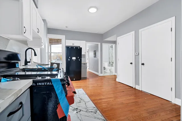 a kitchen with stainless steel appliances granite countertop a stove refrigerator and a sink