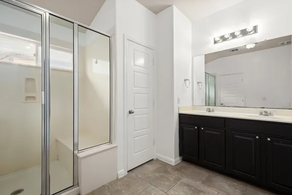 a bathroom with a double vanity sink a mirror and a shower
