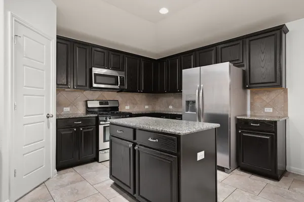 a kitchen with stainless steel appliances granite countertop a refrigerator stove and sink