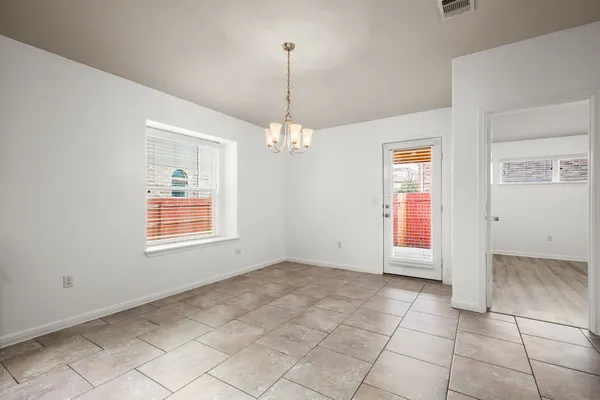 an empty room with windows and chandelier