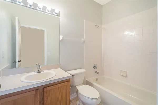 a bathroom with a toilet a sink a mirror and bathtub