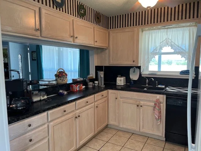 a kitchen with white cabinets and sink