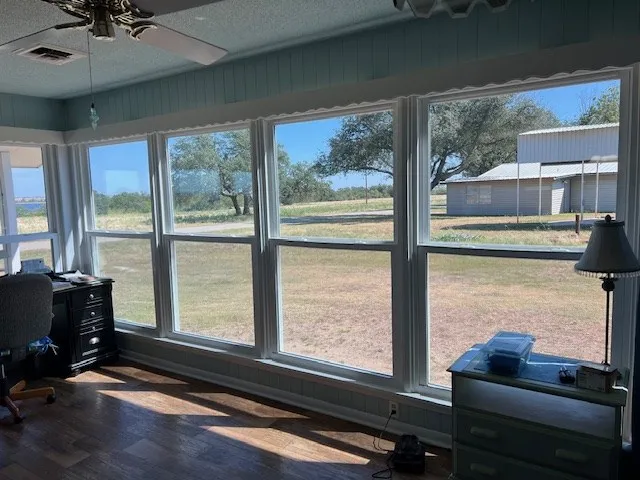 a living room with hardwood floor and large window