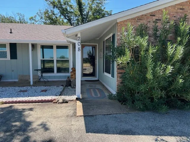 a view of a house with potted plants next to a road