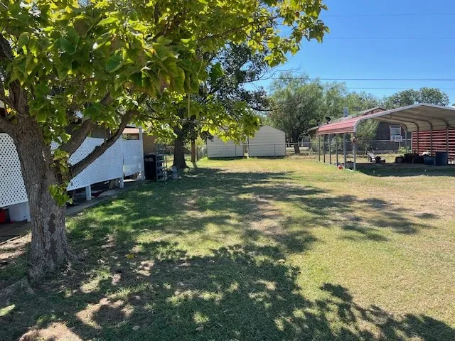 a view of a backyard with large trees