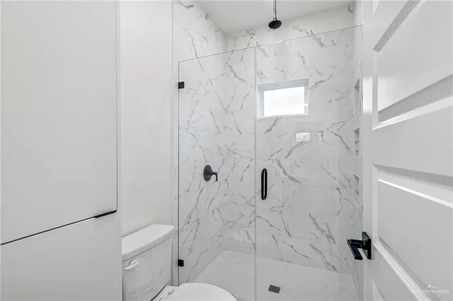 a bathroom with a shower toilet and sink