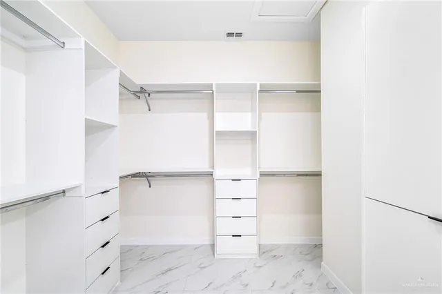 a view of walk in closet with empty racks