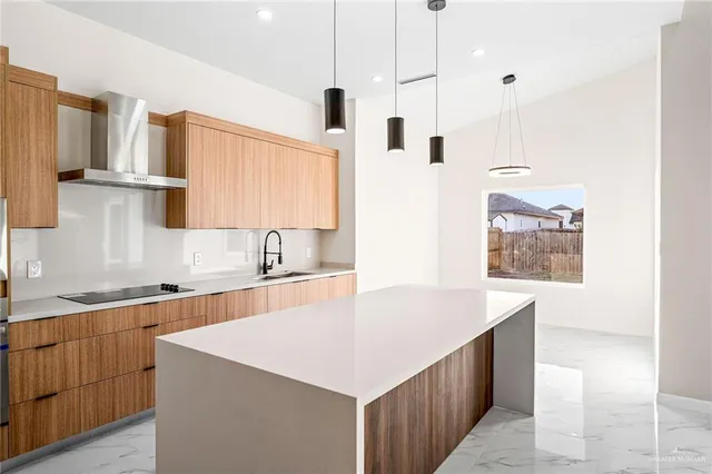 a large kitchen with stainless steel appliances a large counter top a stove and a sink