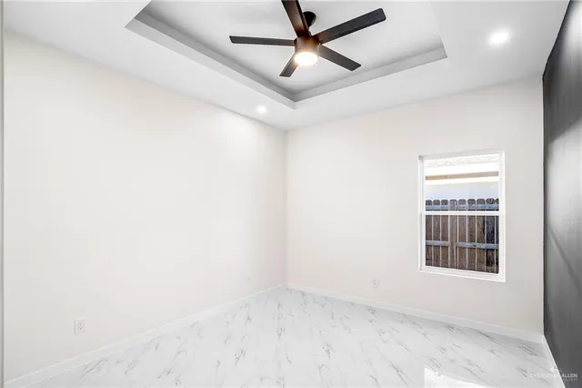 an empty room with a window and ceiling fan