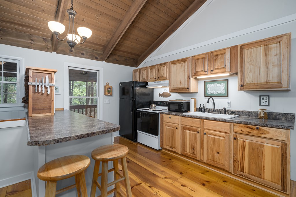 131 Hickory Trace Ellijay, GA 30536 - Photo 23 of 67 a kitchen with stainless steel appliances granite countertop a kitchen island hardwood floor sink stove dining table and chairs