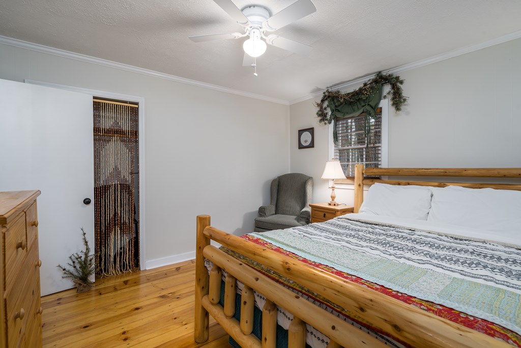 131 Hickory Trace Ellijay, GA 30536 - Photo 35 of 67 a bedroom with a bed and a chandelier