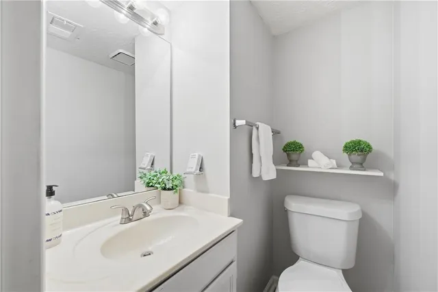 a bathroom with a toilet sink and mirror