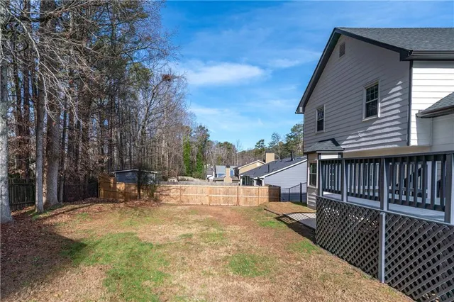 a view of a house with a big yard and large trees