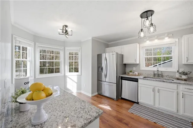 a kitchen with stainless steel appliances granite countertop a sink and a refrigerator