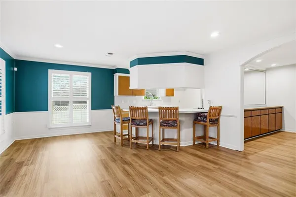 a view of a kitchen with furniture and wooden floor