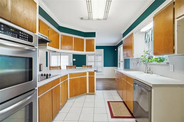 a large white kitchen with stainless steel appliances granite countertop a sink and cabinets