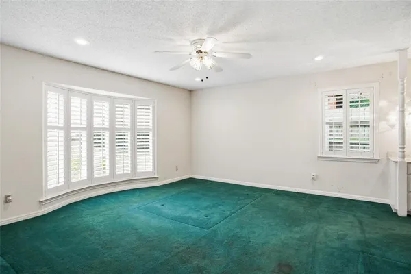 an empty room with fan and windows