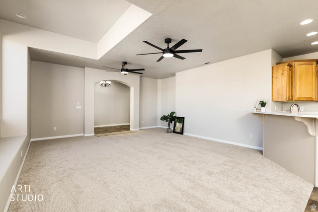 2158 Balboa Way St. George, UT 84770 - Photo 12 of 40 Unfurnished living room with light colored carpet, arched walkways, recessed lighting, a textured ceiling, and ceiling fan
