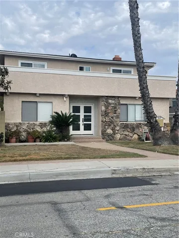 a front view of a house with a garden and plants