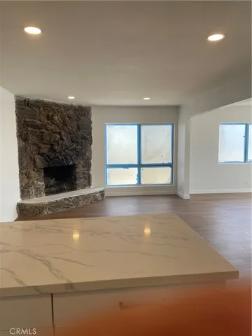 a view of an empty room with a fireplace and a large window
