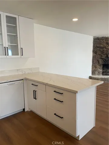 a kitchen with granite countertop white cabinets and a sink