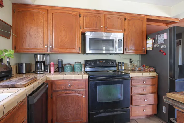 a kitchen with granite countertop a stove top oven microwave and cabinets