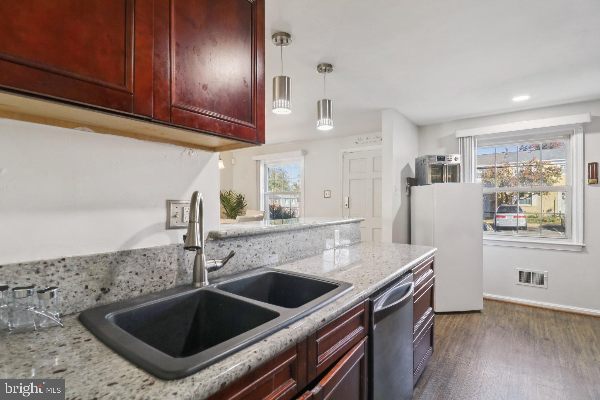 1456 Potomac Heights Drive, Unit 145 Fort Washington, MD 20744 - Photo 17 of 50 a kitchen with granite countertop a sink and a stove top oven with wooden floor