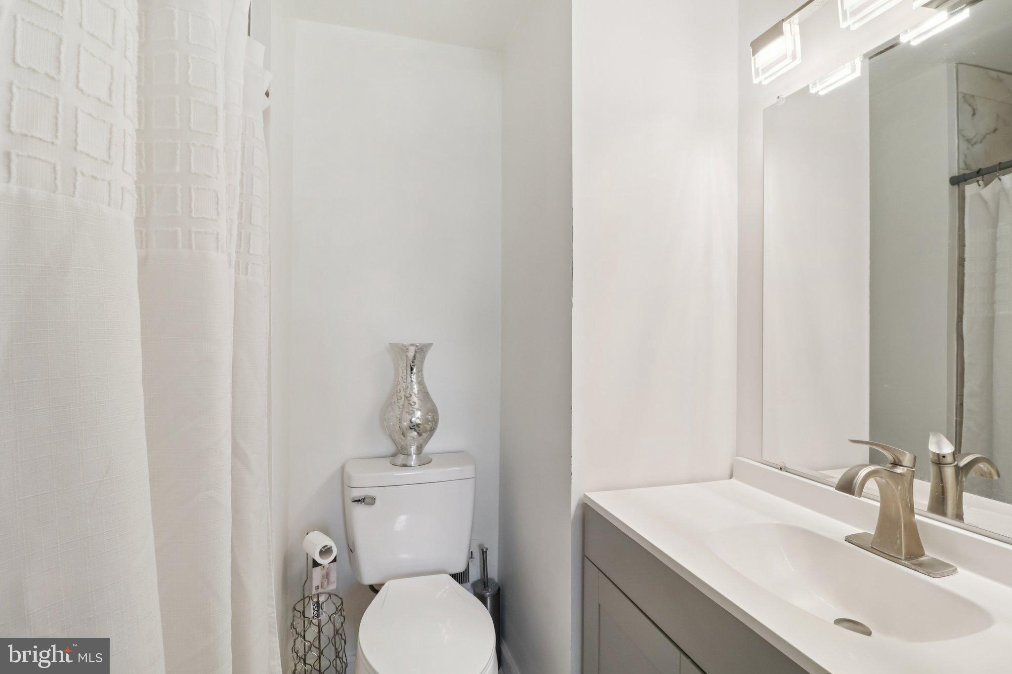 1456 Potomac Heights Drive, Unit 145 Fort Washington, MD 20744 - Photo 27 of 50 a bathroom with a toilet sink and mirror