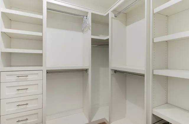 a view of walk in closet with empty racks