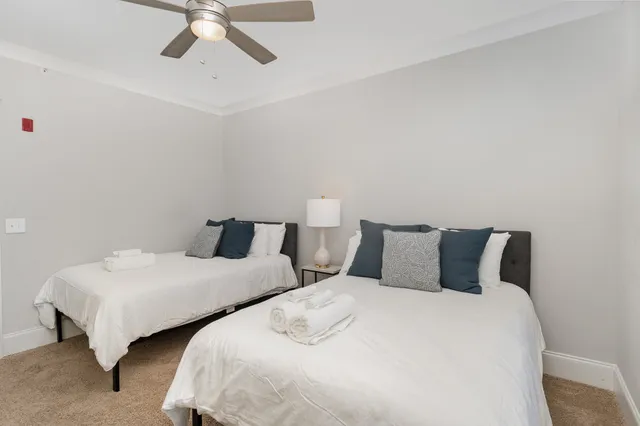 a bedroom with two beds and a chandelier