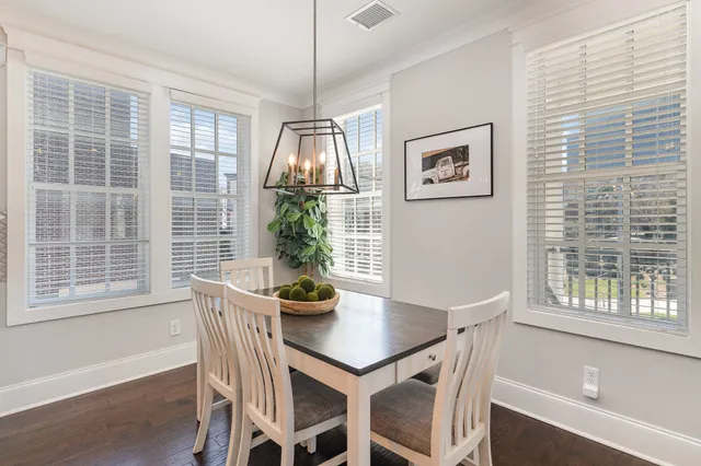 a view of a dining room with furniture large windows and wooden floor